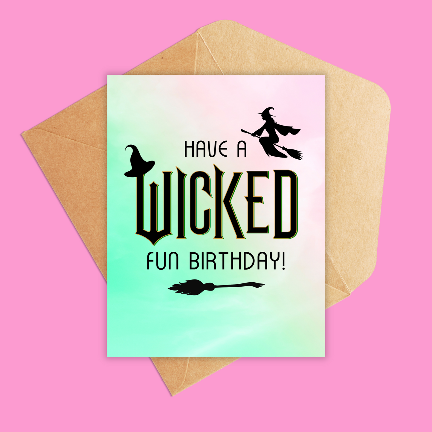 Pink and green card with the text 'Have a wicked fun birthday!' has a broomstick, witch hat and a flying witch on the front of card. Shown with a brown kraft envelope