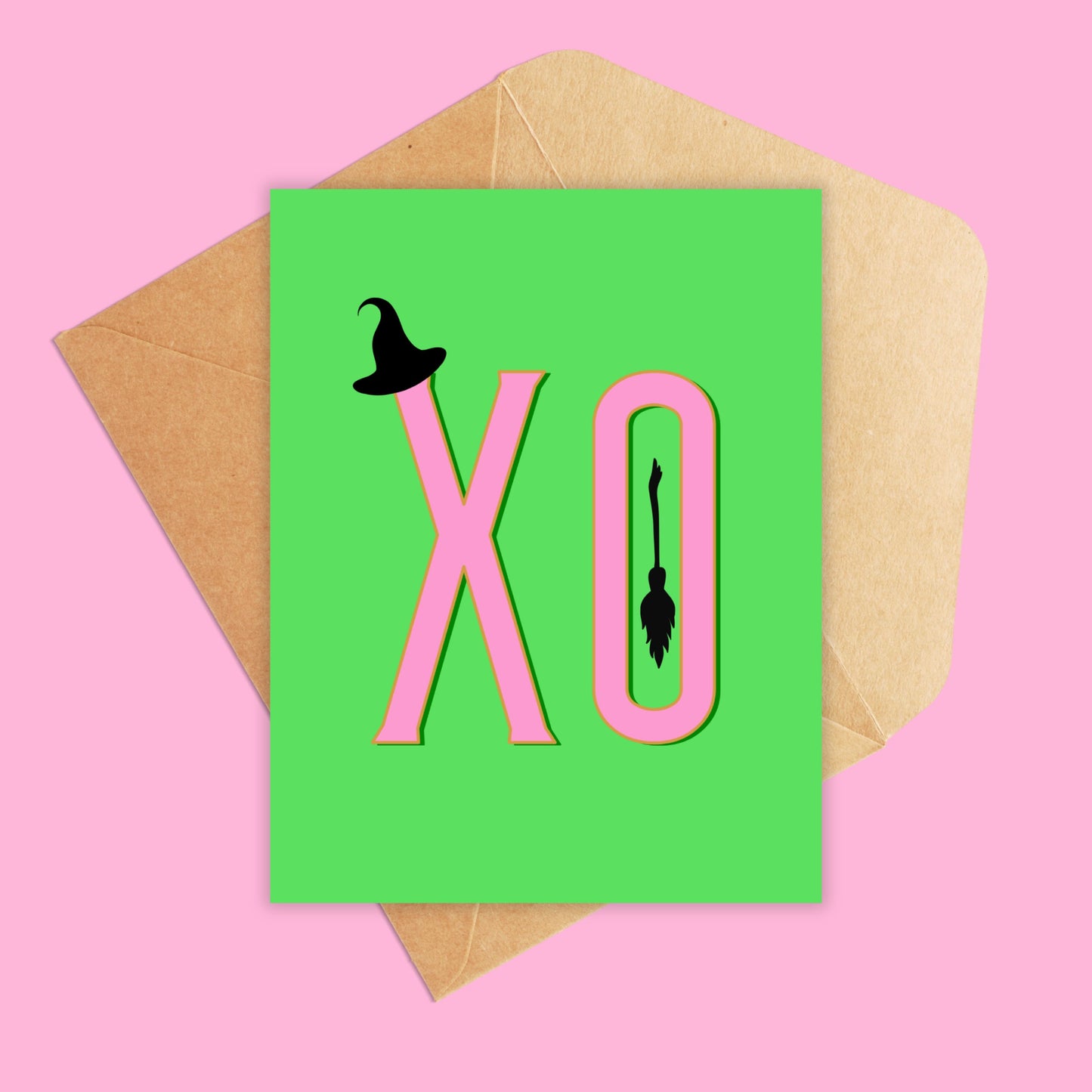 Portrait greeting card with a green background and xo in pink with a tiny witch hat and broomstick