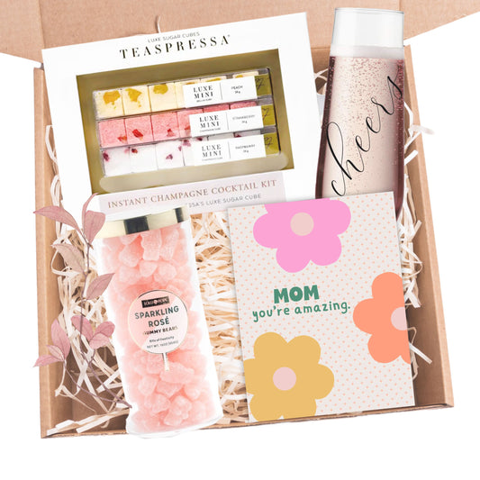 gift set for mom containing a champagne cocktail sugar cube kit, sparkling rose sugar gummy bears, cheer flute and a card that says mom, you're amazing.