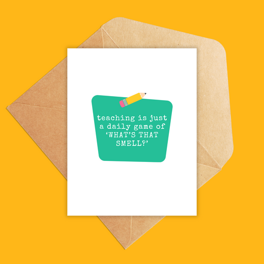 Portrait size greeting card with white background and green center block. Inside the block text reads "teaching is just a daily game of what's that smell?
