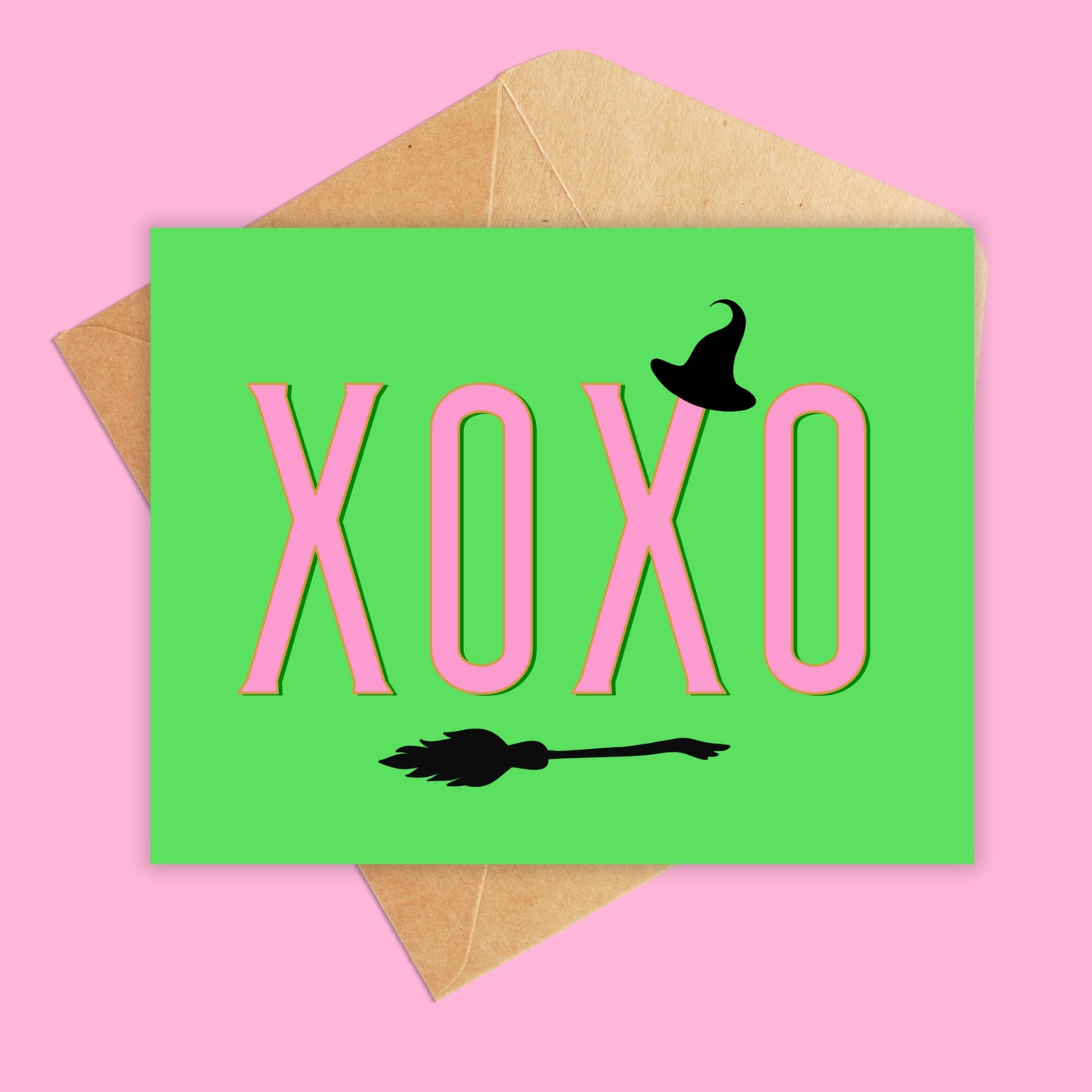 Landscape greeting card with a bright green background and xoxo going across in pink. Has a small witch hat and broomstick in black. 