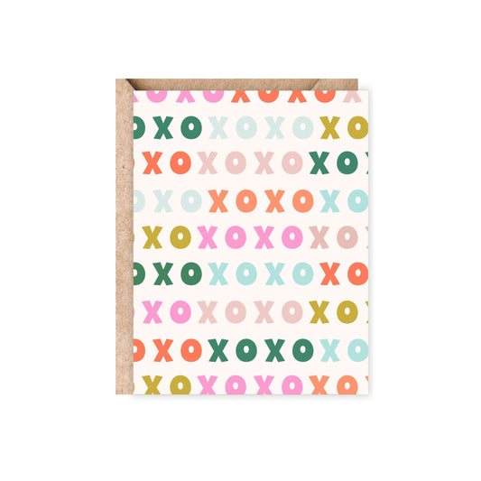 greeting card with a xoxo raibow pattern in green, mint, mustard yellow, pink and orange and blush