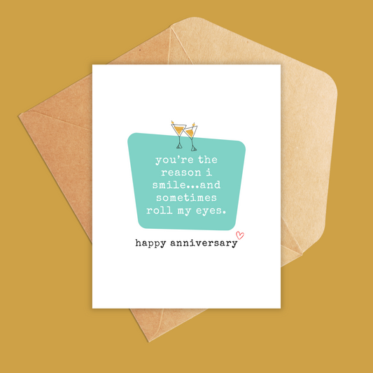 White greeting card with a teal box and text inside says 'you're the reason i smile...and sometimes roll my eyes. happy anniversary